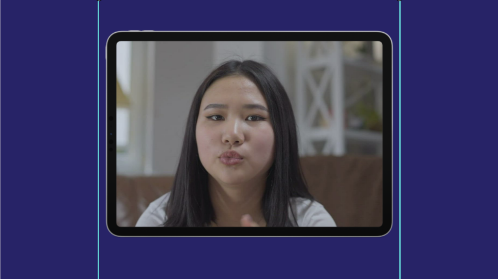 A woman blowing a kiss towards the camera on a tablet screen.