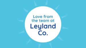 Graphic with text "love from the team at leyland co." centered in a white circle against a light blue background with starburst pattern, created using Biteable video maker.