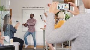 A person recording a video with Biteable video maker of a colleague presenting in a casual office meeting.