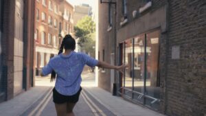 A woman jogging in an urban alleyway, captured through the Biteable video maker.