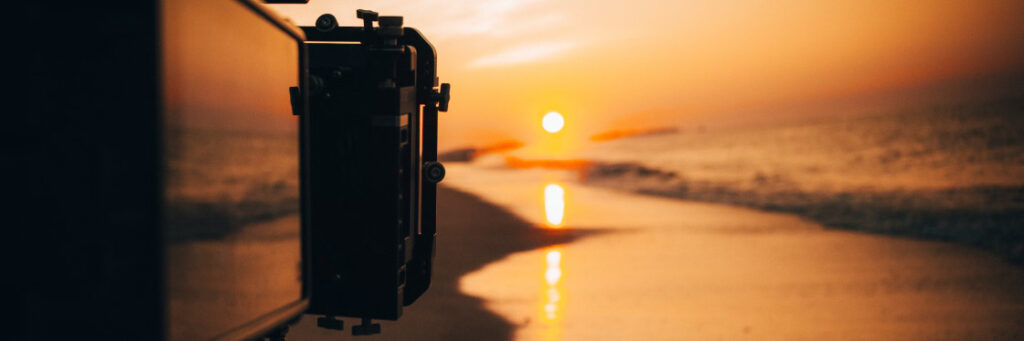 A Biteable video maker captures a sunset over the ocean, recording the reflection of the sun on the water's surface.