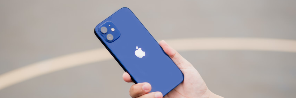 Hand holding a blue iPhone 12 with dual cameras, displayed against a Biteable video maker background.