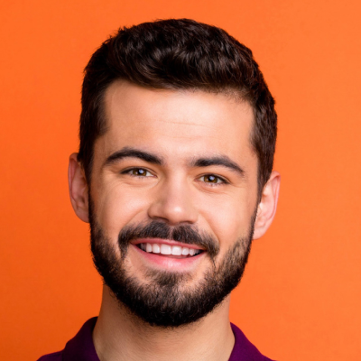 Headshot of a smiling man with a beard, wearing a purple shirt, against an orange background.