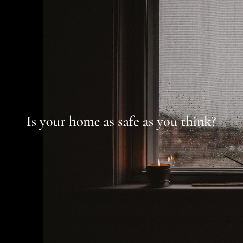 A candle burns on the windowsill of a darkened room with text overlaying the image: "Is your home as safe as you think?.