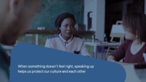 Three people sit at a table having a discussion. Text on the image reads: "When something doesn’t feel right, speaking up helps us protect our culture and each other.
