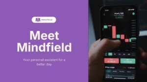 A promotional graphic for Mindfield shows its logo and slogan on the left and a hand using a cryptocurrency trading app on a smartphone on the right.