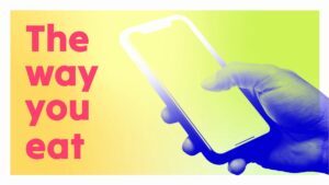 A hand holding a smartphone next to large text that reads "The way you eat" on a yellow and green gradient background.