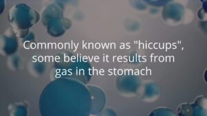 Blue and gray spheres float in the background with text stating: "Commonly known as 'hiccups', some believe it results from gas in the stomach.