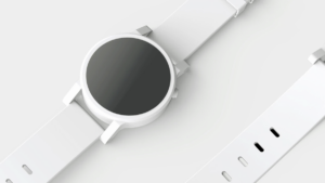 A white smartwatch with a blank black screen and a white wristband lies on a light surface.