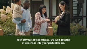 A real estate agent shows documents to a young family with a small child outside a home. Text overlay reads: "With 30 years of experience, we turn decades of expertise into your perfect home.