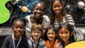 Six young children smile together indoors with a space-themed background featuring planets and stars.
