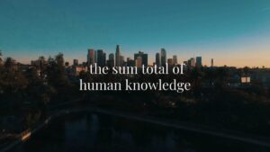 A city skyline at sunset with the words "the sum total of human knowledge" written in white text across the sky.
