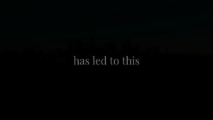 Dark image with faint city skyline silhouette and centered text reading "has led to this" in light gray font.